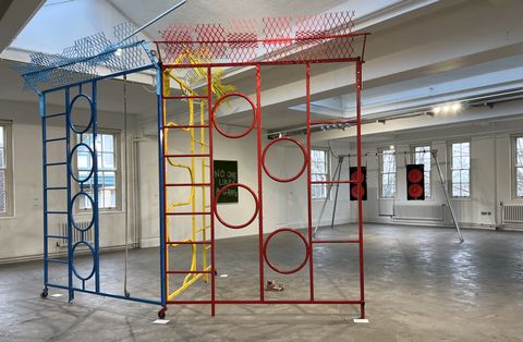 Colourful sculptural framework installed in a gallery.